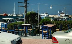 Ostrovní směs, modré stoly a židle, lodě a ... Favorit s řeckou SPZ.